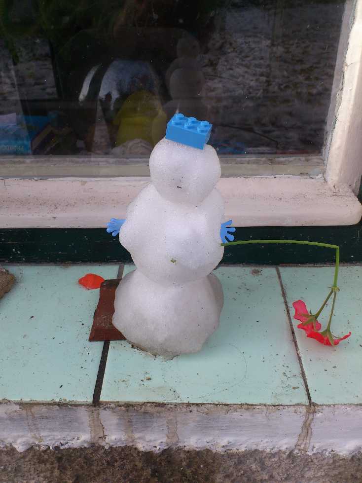 Malý sněhuláček s neobvyklým koštětem z květu muškátů